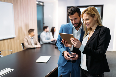 Businesspeople discussing while using digital tablet in officeの写真素材