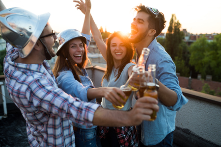 Group of happy friends having party on rooftopの写真素材
