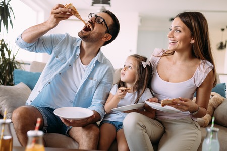 Portrait of happy family sharing pizza at homeの写真素材
