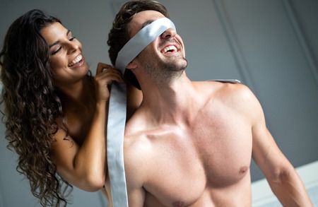 Young couple being intimate in bedroom. Sensual lovers making love in bedroom.の写真素材