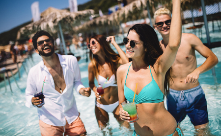 Group of friends having fun at summer party and drinking cocktailの写真素材