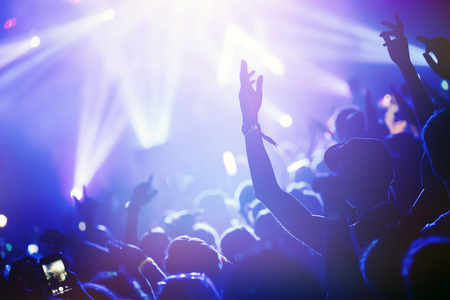 Cheering crowd at concert enjoying music performanceの写真素材