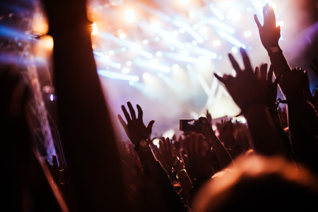 Cheering crowd at concert enjoying music performanceの写真素材