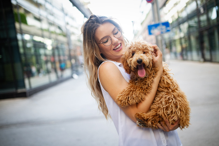 Beauty woman with her dog playing outdoorsの写真素材
