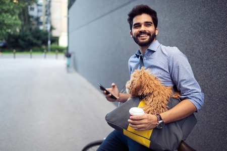 Happy handsome man with bicycle using mobile outdoor
