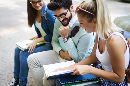 Happy university friends studying together in collegeの写真素材