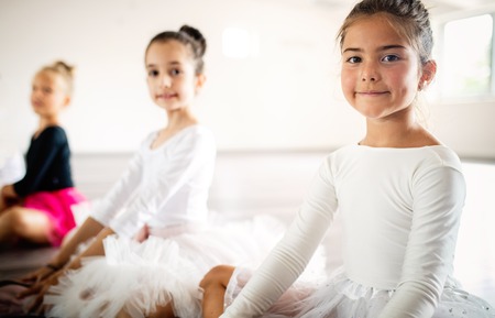 Group of fit happy children exercising ballet in studio togetherの写真素材
