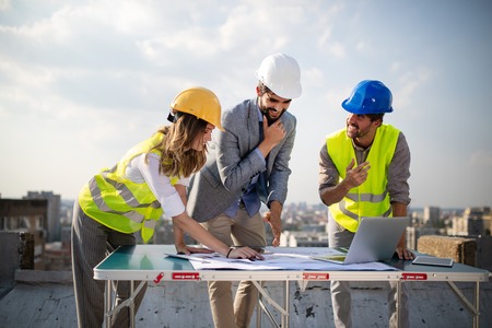 Team of architects people in group on construciton site check documents and business workflow.