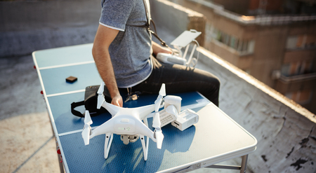 Man with drone flying at the city on rooftop