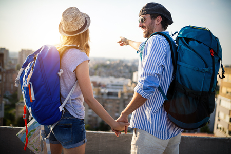 Multiethnic traveler couple using map together on sunny dayの写真素材