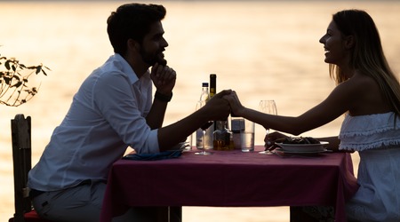 Happy couple on summer evening having romantic dinner outdoorの写真素材