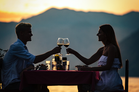 People, vacation, love and romance concept. Young couple enjoying a romantic dinner on beach.の写真素材