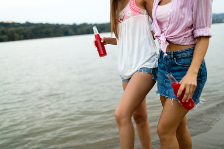 Beautiful women on beach drinking cocktails on summer vacationの写真素材