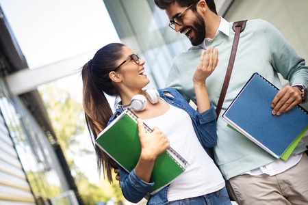 Happy university friends studying together in collegeの写真素材