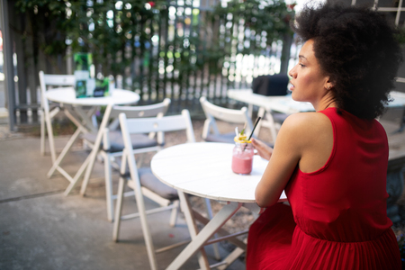 Beautiful happy black woman drinking healthy drink and smilingの写真素材