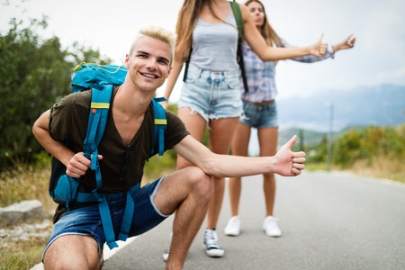 Group of friends backpackers walking and traveling outdoorの写真素材