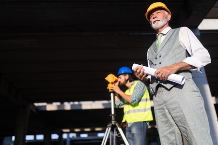 Confident team of architects and engineers working together on construction siteの写真素材