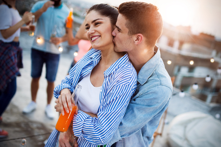 Happy couple enjoying drinks and balcony party.の写真素材