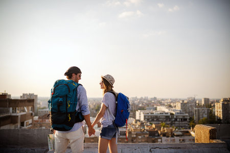 Multiethnic traveler couple using map together on sunny day