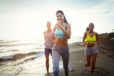 Group of sport people running on the beachの写真素材