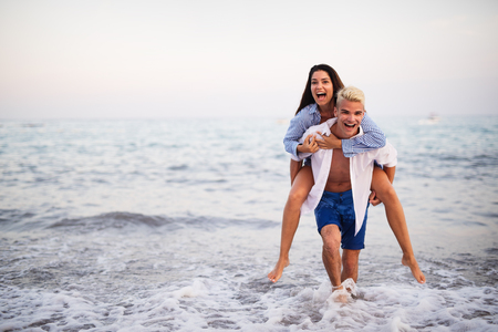 Happy young couple having fun and love on the beachの写真素材