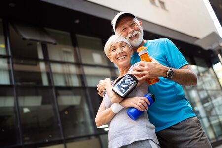 Healthy senior, couple jogging in the city at early morning with sunrise