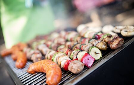Assorted meat from chicken, pork and various vegetables on barbecue grillの写真素材