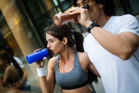 Young happy fitness friends running in urban areaの写真素材