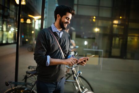 Portrait of young businessman holding tablet outdoorの写真素材