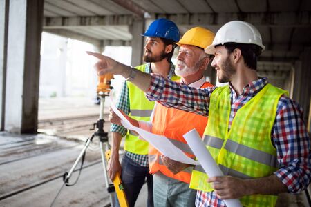 Engineer, foreman and worker discussing in building construction siteの写真素材