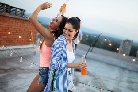 Beautiful women friends on the balcony having fun at party.の写真素材