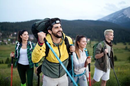 Adventure, travel, tourism, hike and people concept - group of smiling friends with backpacks and map outdoorsの写真素材