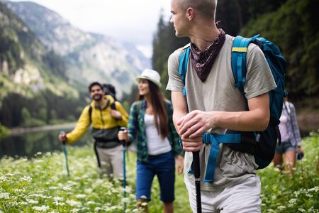 Group of friends hikers walking on a mountain at sunsetの写真素材