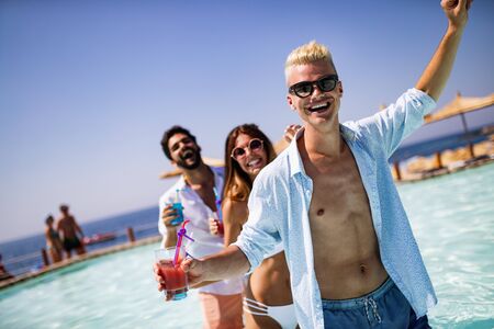 Group of friends having fun at summer party and drinking cocktailの写真素材