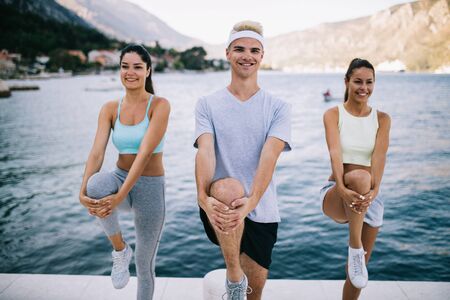 Group of happy people exercising outdoor. Sport, fitness, friendship and healthy lifestyle conceptの写真素材