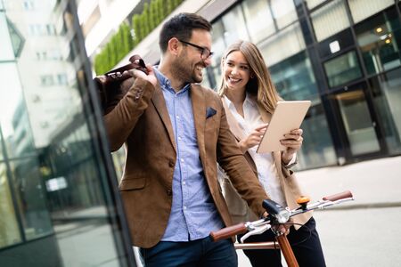 Happy business colleagues talking and walking in the city outdoorの写真素材