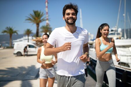Running, friends, sport, exercising and healthy lifestyle concept. Happy people jogging outdoor.の写真素材