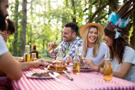 Happy friends camping and having a barbecue in natureの写真素材