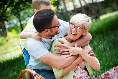 Happy family playing and enjoying picnic with children outsideの写真素材