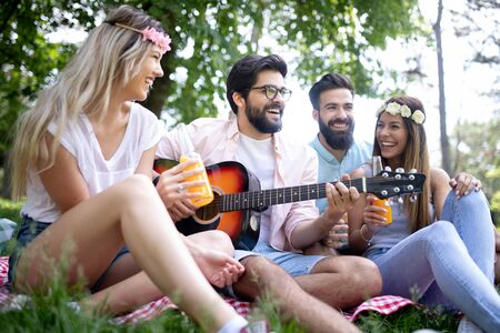 Summer, vacation, music and recreation time concept. Group of friends have picnic outdoor.