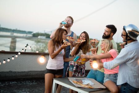 Group of young people having fun at a summertime party, at sunsetの写真素材