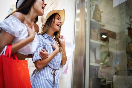 Happy friends women shopping in the city on vacationの写真素材