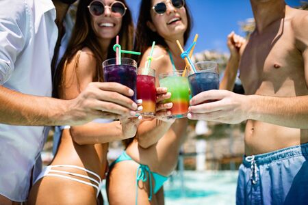 Group of friends having fun at summer party and drinking cocktailの写真素材
