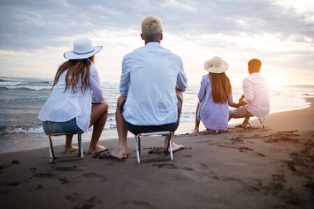 Group of friends enjoying summer vacation at sunset on beachの写真素材
