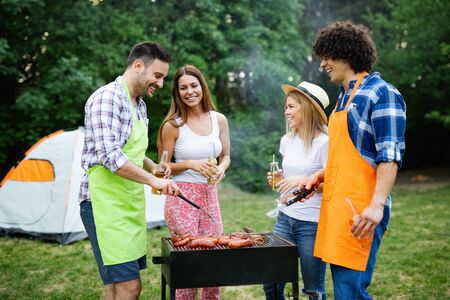Group of happy friends having a barbecue party in natureの写真素材