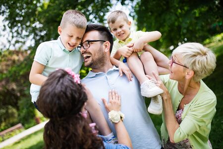 Happy family playing and enjoying picnic with children outsideの写真素材