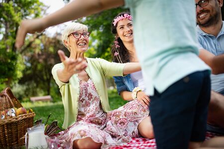 Happy family playing and enjoying picnic with children outsideの写真素材