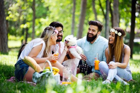 Happy group of friends relaxing and having fun on picnic in natureの写真素材