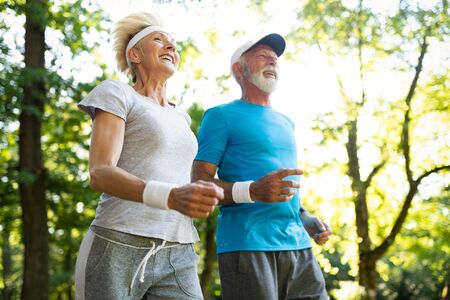 Happy senior couple staying fit by sport runningの写真素材