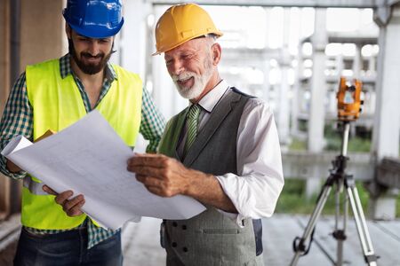 Engineer, foreman and worker discussing in building construction site